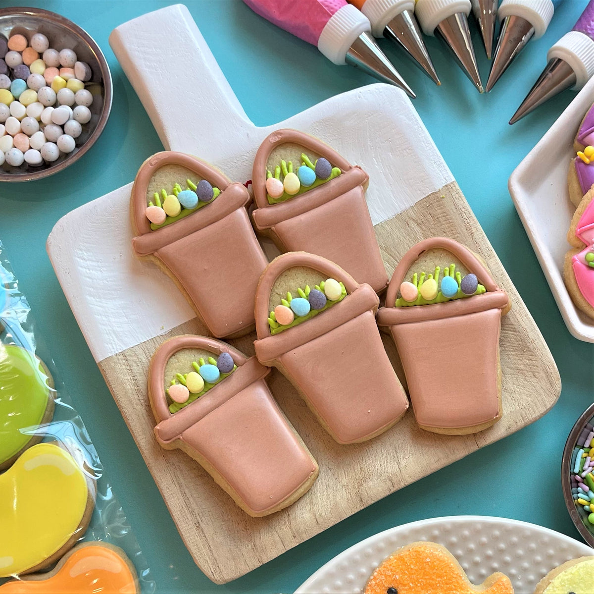Mini Easter candy cookie cutter bundle with pastel pink flower pot cookies decorated with candy eggs and green icing