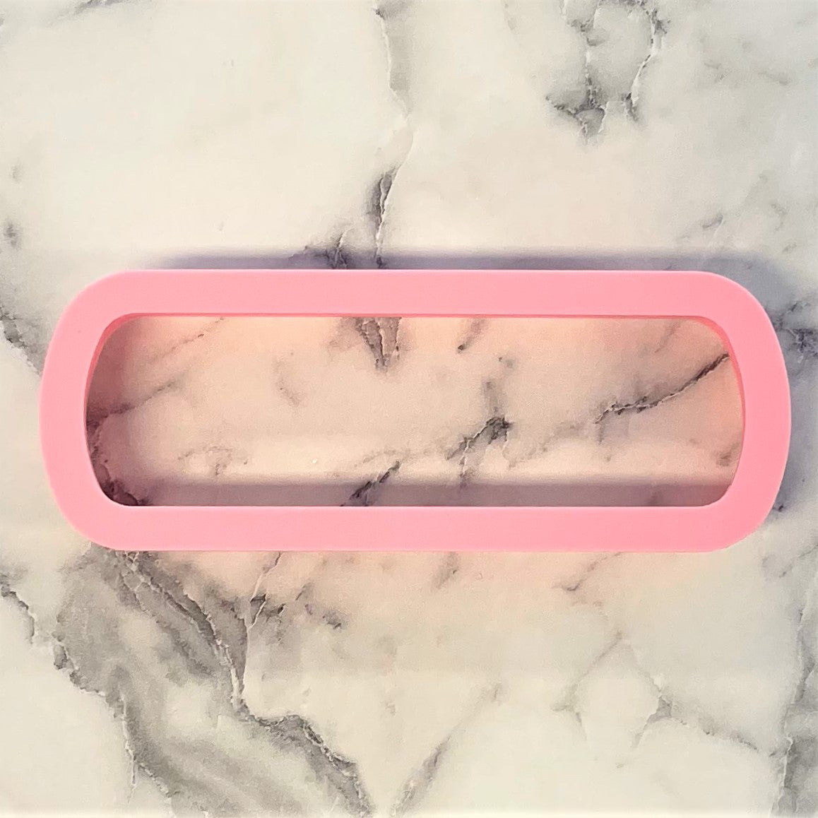 Pink silicone nail file cookie cutter mold with smooth rounded edge and transparent interior for baking use
