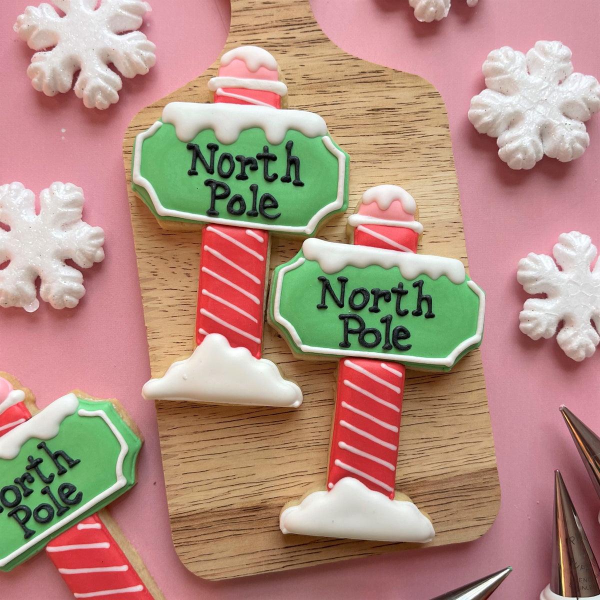 North pole cookie decorating class recording featuring green and red frosted north pole candy cane cookies with snow topping