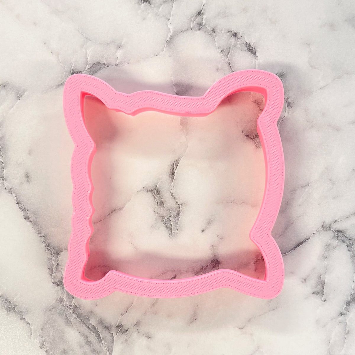 Pink plastic cat-shaped pillow cookie cutter for shaping cookies and pastries
