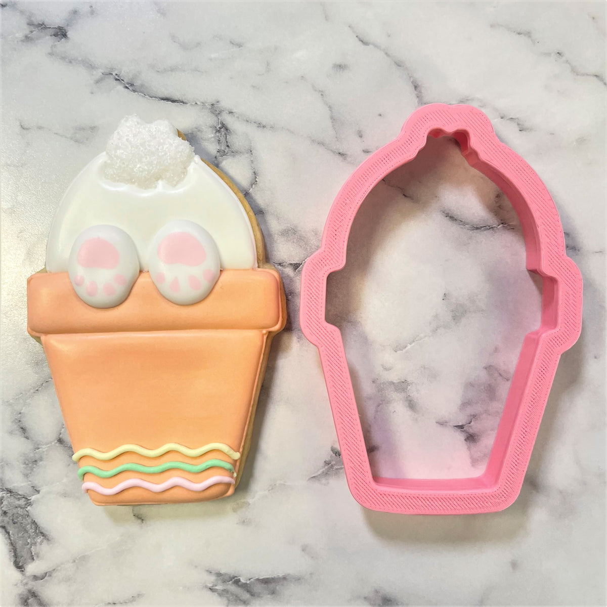 Potted bunny butt cookie cutter in pink silicone with a smooth textured surface and rounded edges for baking use