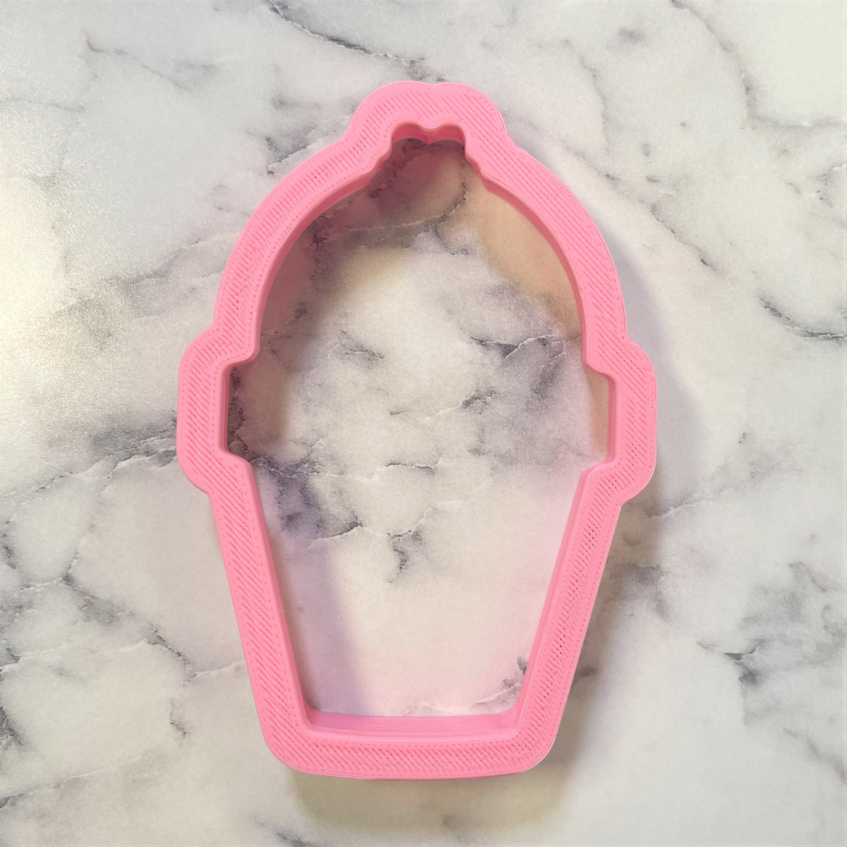 Pink plastic potted bunny butt cookie cutter with a marbled interior for baking and crafting use