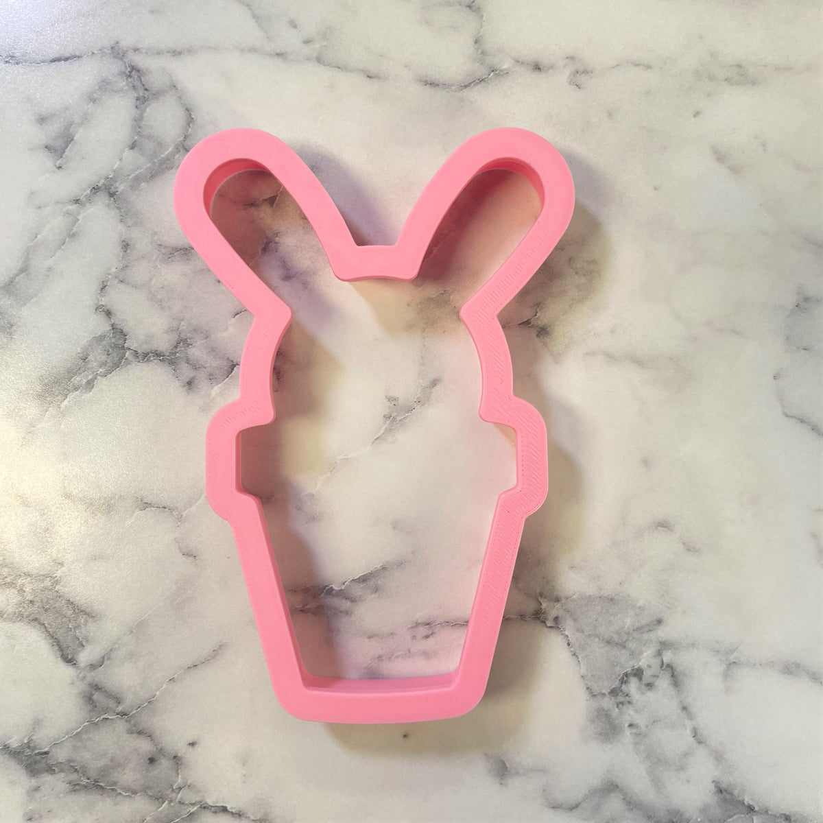 Pink silicone bunny shaped cookie cutter for potted bunny themed baking and decorating projects