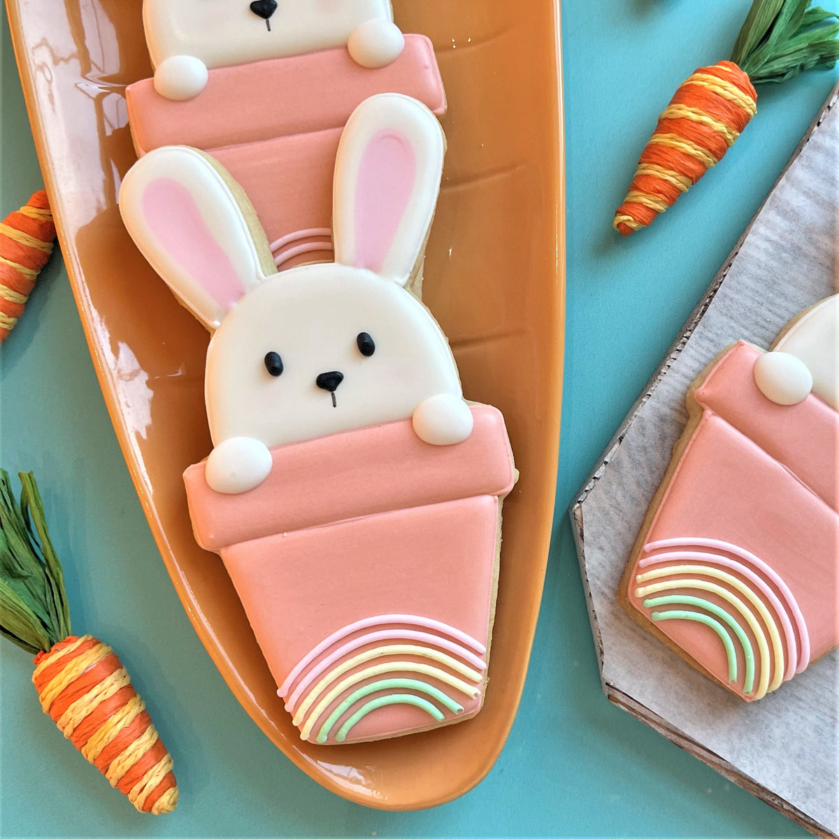 Potted bunny cookie cutter with pastel pink sugar bunny shaped cookie featuring rainbow icing details in a flower pot