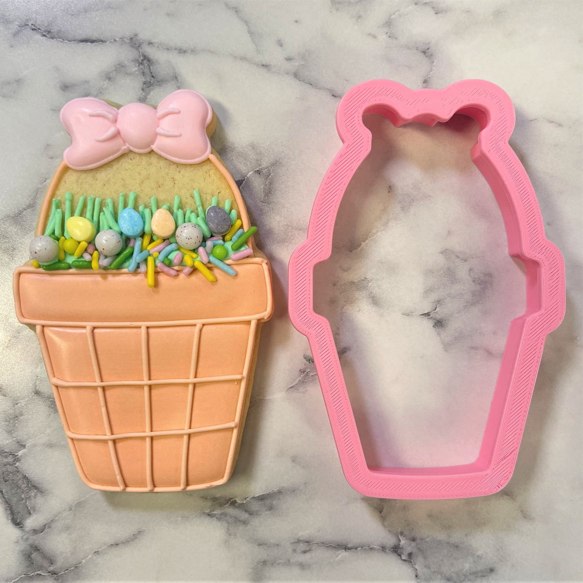 Pink plastic potted basket cookie cutter with bear shaped outline and textured edges for easter baking