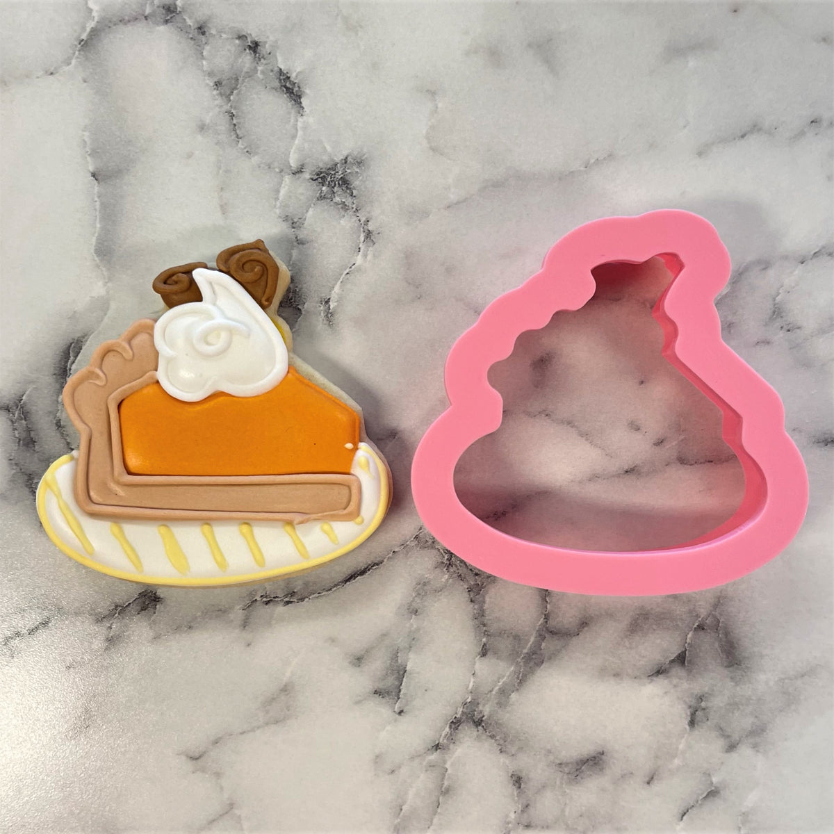 Mini pumpkin pie on plate cookie cutter in pink silicone with detailed orange pumpkin pie design and whipped cream accents