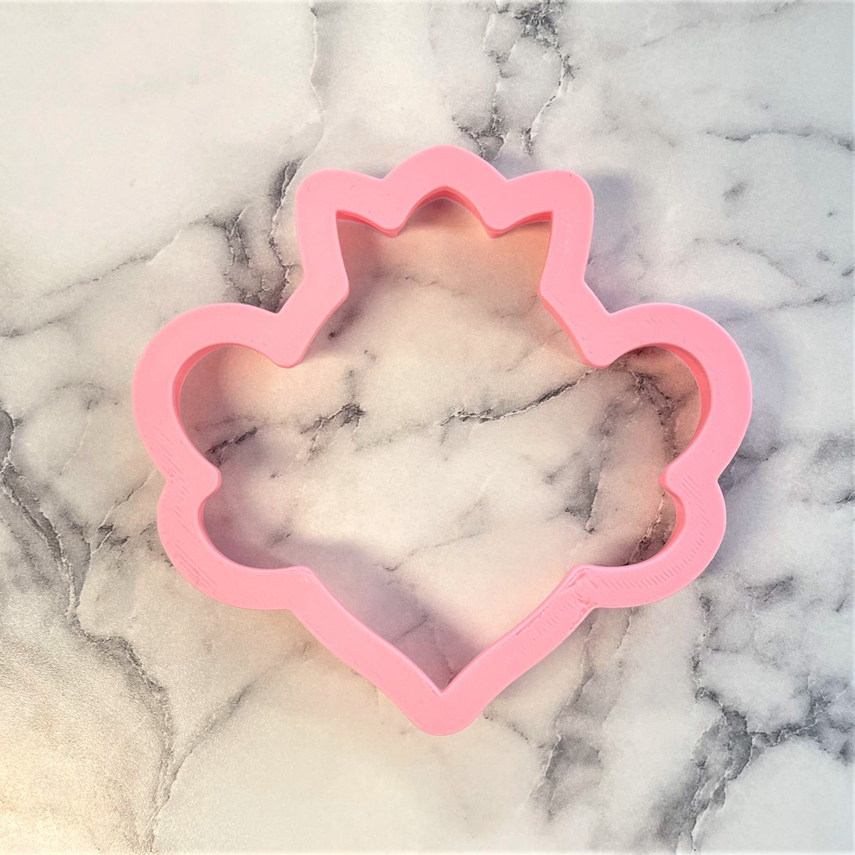 Pink silicone cookie cutter shaped like a crown for baking queen bee themed cookies