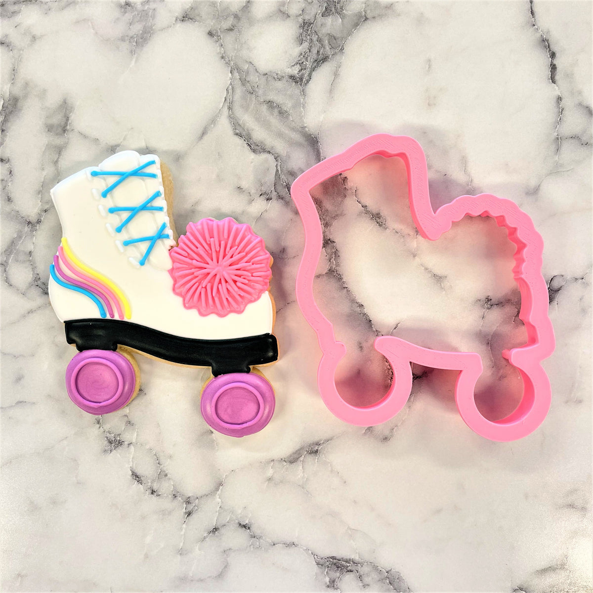 A pink roller skate cookie cutter with a smooth glossy finish perfect for making pom pom themed cookies