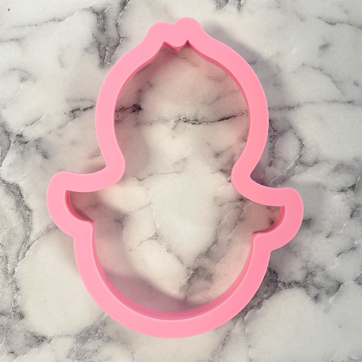 Pink silicone penguin roly poly cookie cutter shaped like a cartoonish ghost for baking and crafting