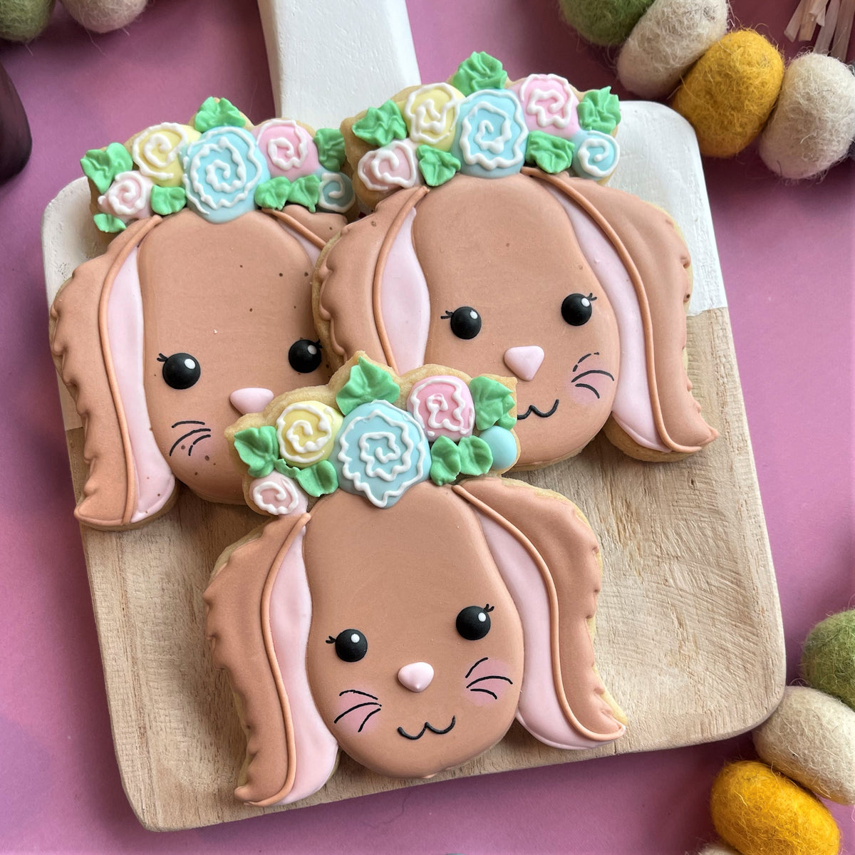 Pastel-colored sugar cookies shaped like bunnies with floral crowns made using a floral bunny cookie cutter
