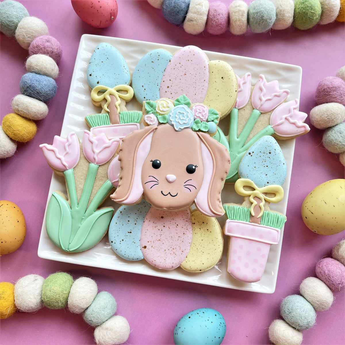Pastel-colored sugar cookie shaped like a bunny with floral icing decorations made using a floral bunny cookie cutter