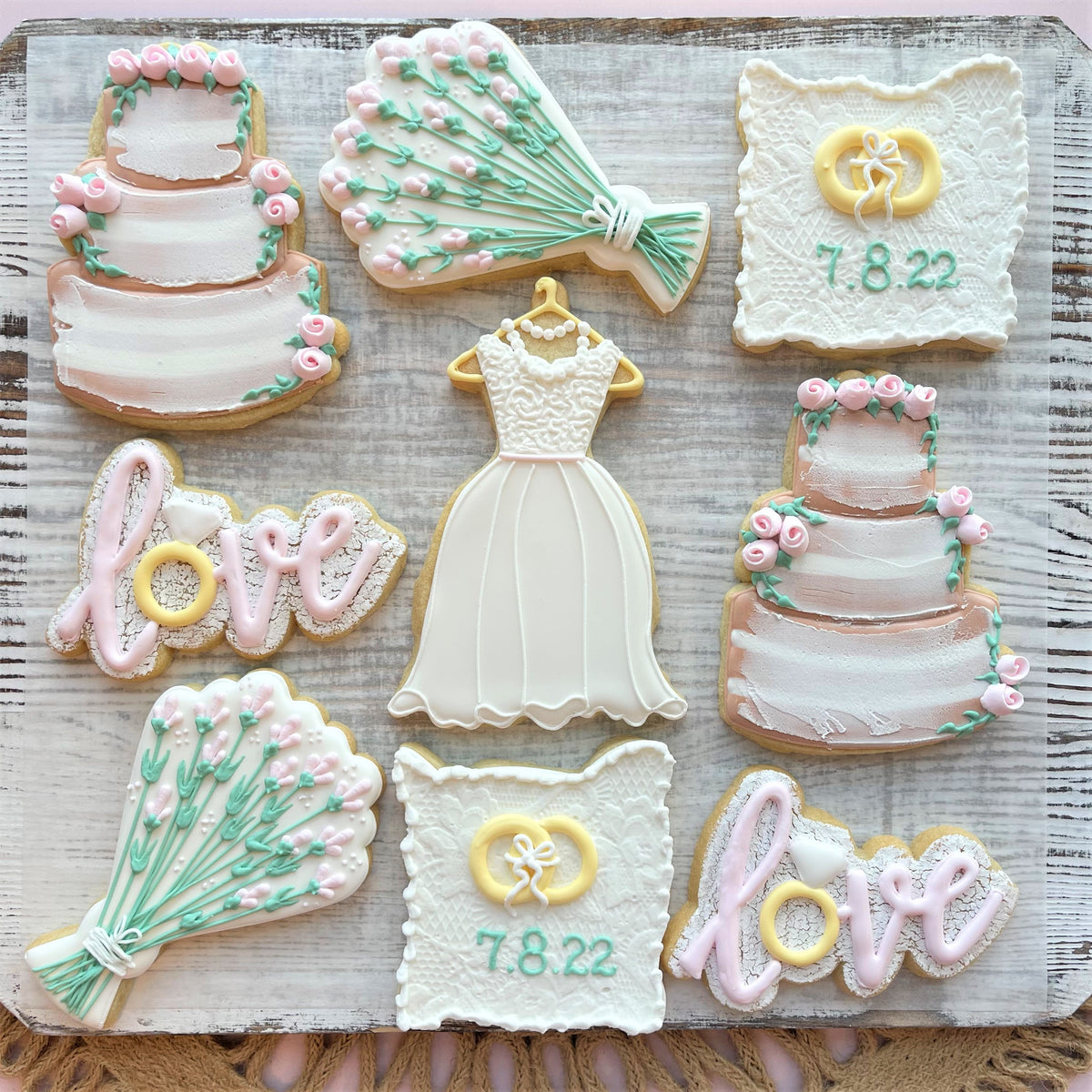 A delicate white wedding dress cookie with lace detailing and a pearl necklace from rustic wedding cookie class recording