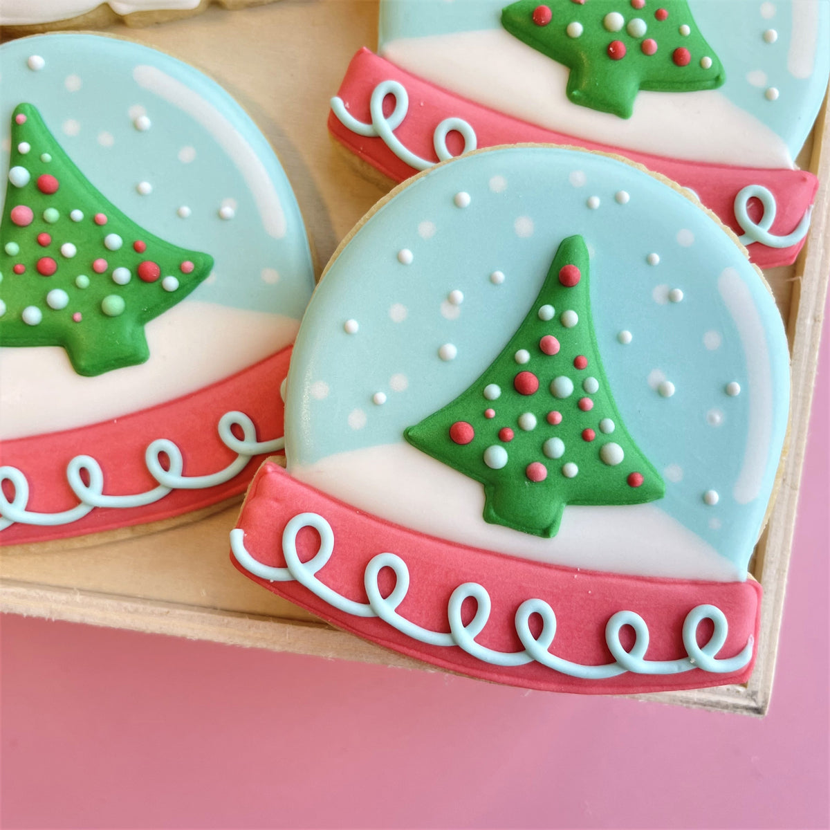 Delicate snow globe cookies with green christmas tree and red white dots on light blue snowy background holly jolly bundle