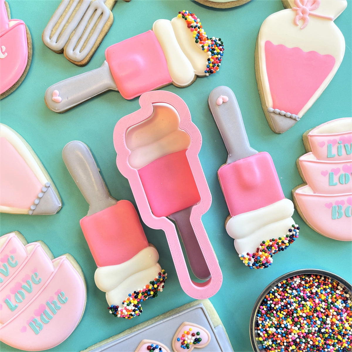 Pink and white plastic spatula cookie cutter with handle for shaped ice cream scoop cookies