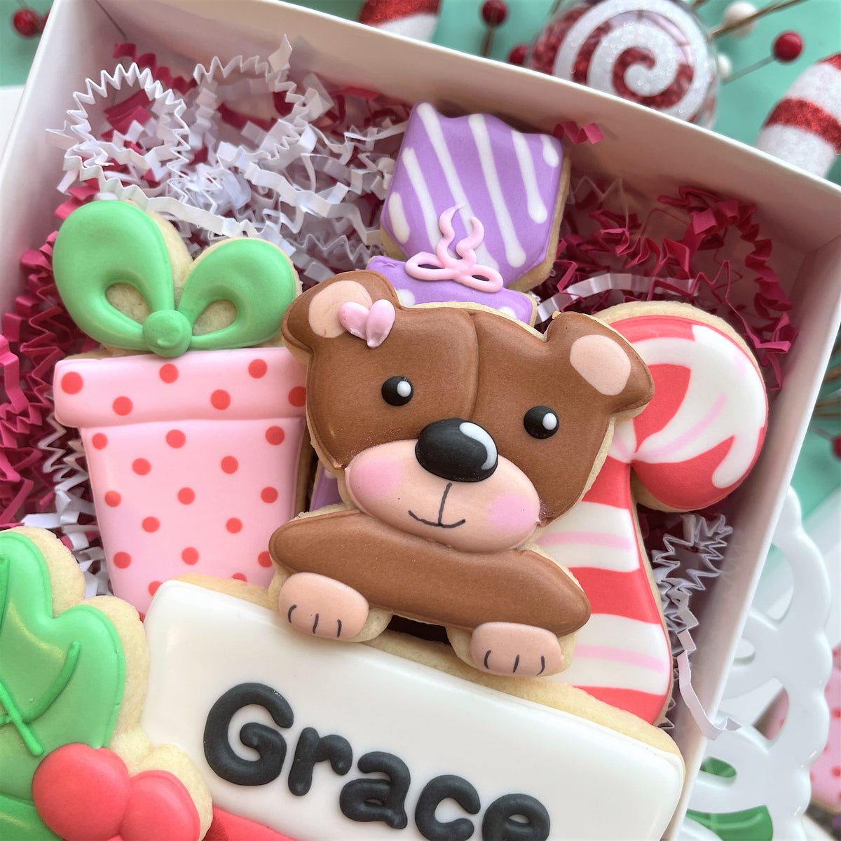 A charming brown bear-shaped cookie with pink cheeks and bow made using present with bow small cookie cutter