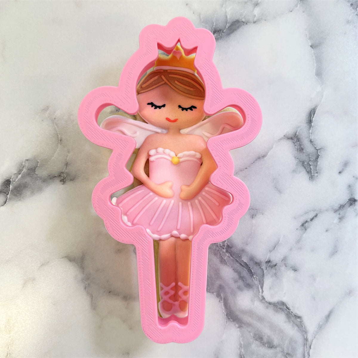Pink plastic ballet fairy cookie cutter with crown and wings for sugar plum fairy themed baking