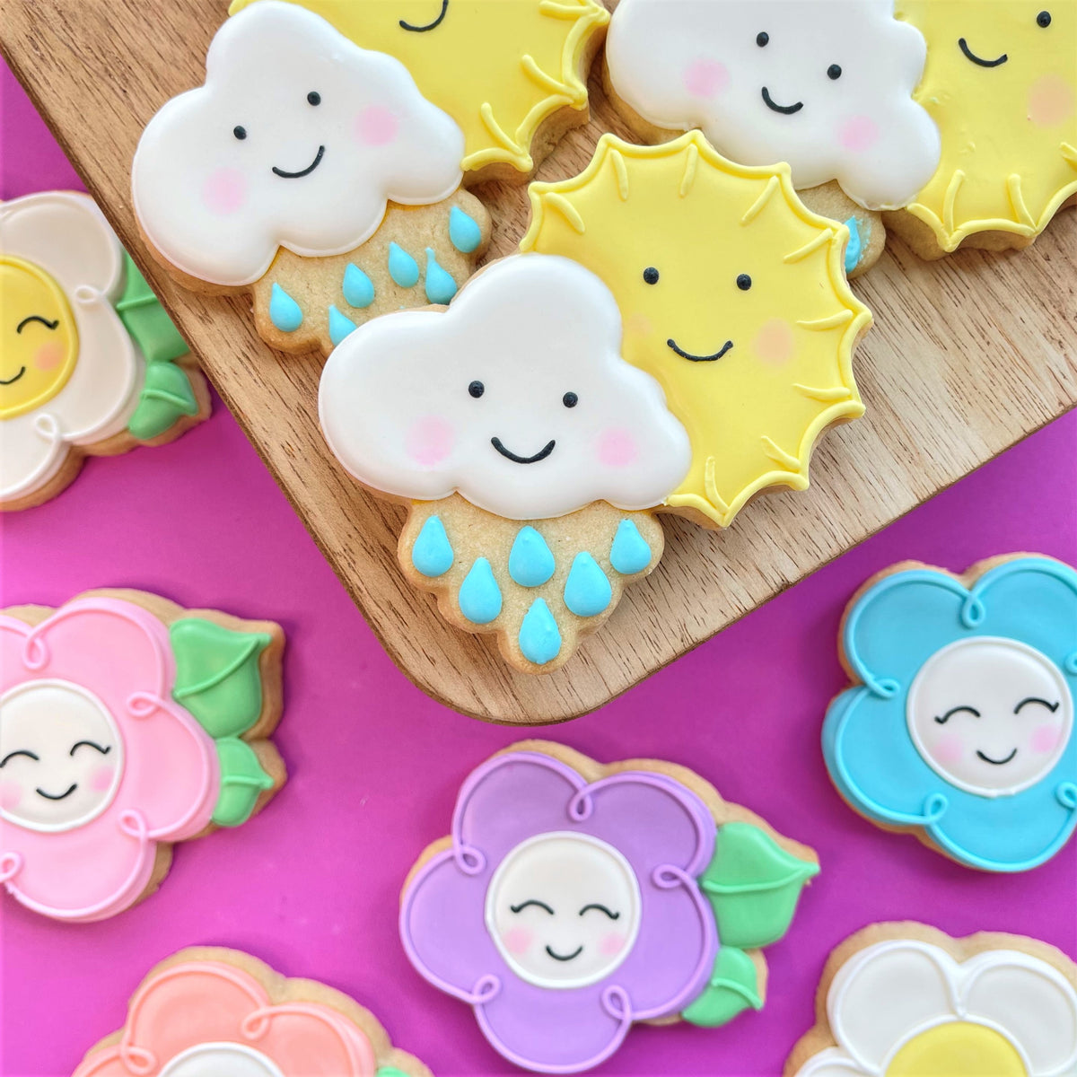 Delicate sugar cookies shaped like smiling clouds and suns with pastel icing from spring showers to flowers class recording