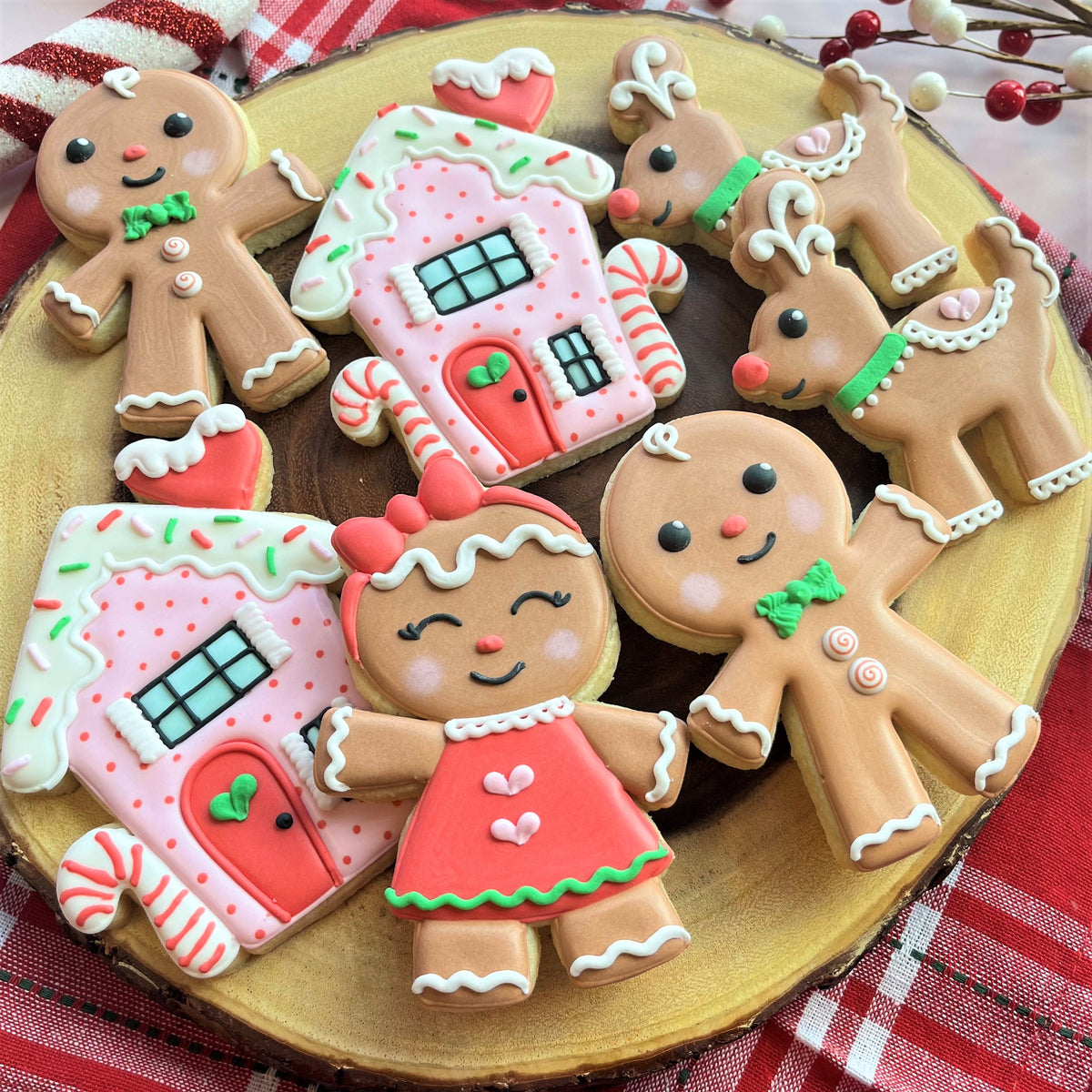 Gingerbread reindeer cookie cutter shaped cookies decorated with pink frosting green accents white icing and candy cane motifs