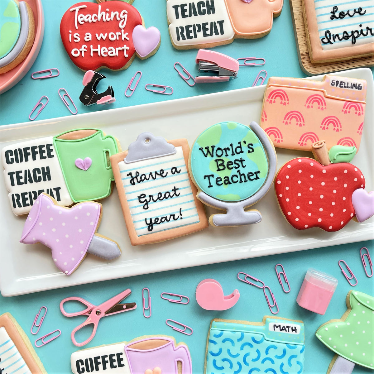 A red apple-shaped cookie with white polka dots and green leafy top made using coffee teach repeat cookie cutter and stencil