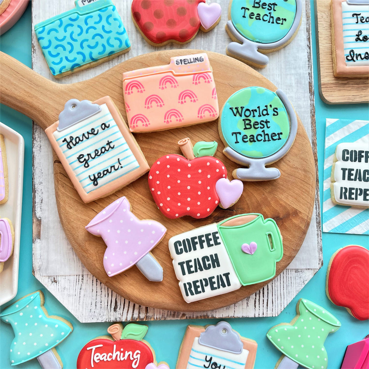 Red polka-dotted apple-shaped cookie decorated with green leaf and brown stem from teacher school tools cookie cutter set