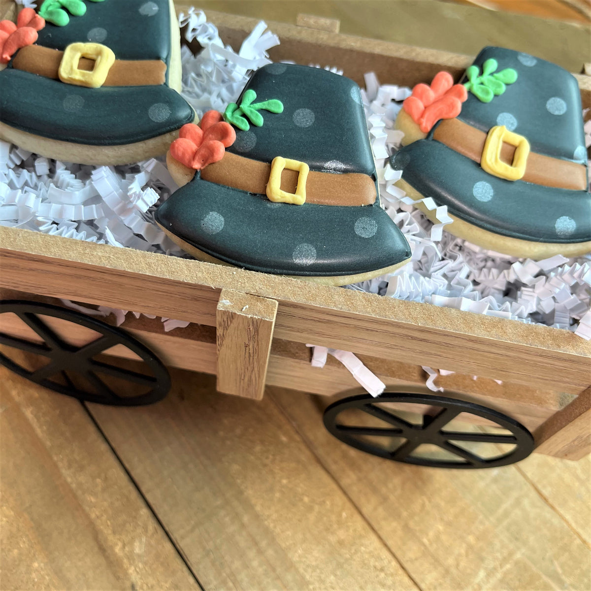 Mini thanksgiving hat cookie cutter shaping dark green sugar cookies decorated with brown belts yellow buckles and orange carrots