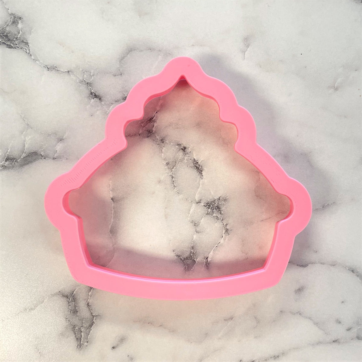 Pink silicone Thanksgiving pie cookie cutter shaped like a cupcake with scalloped edges for baking and decorating