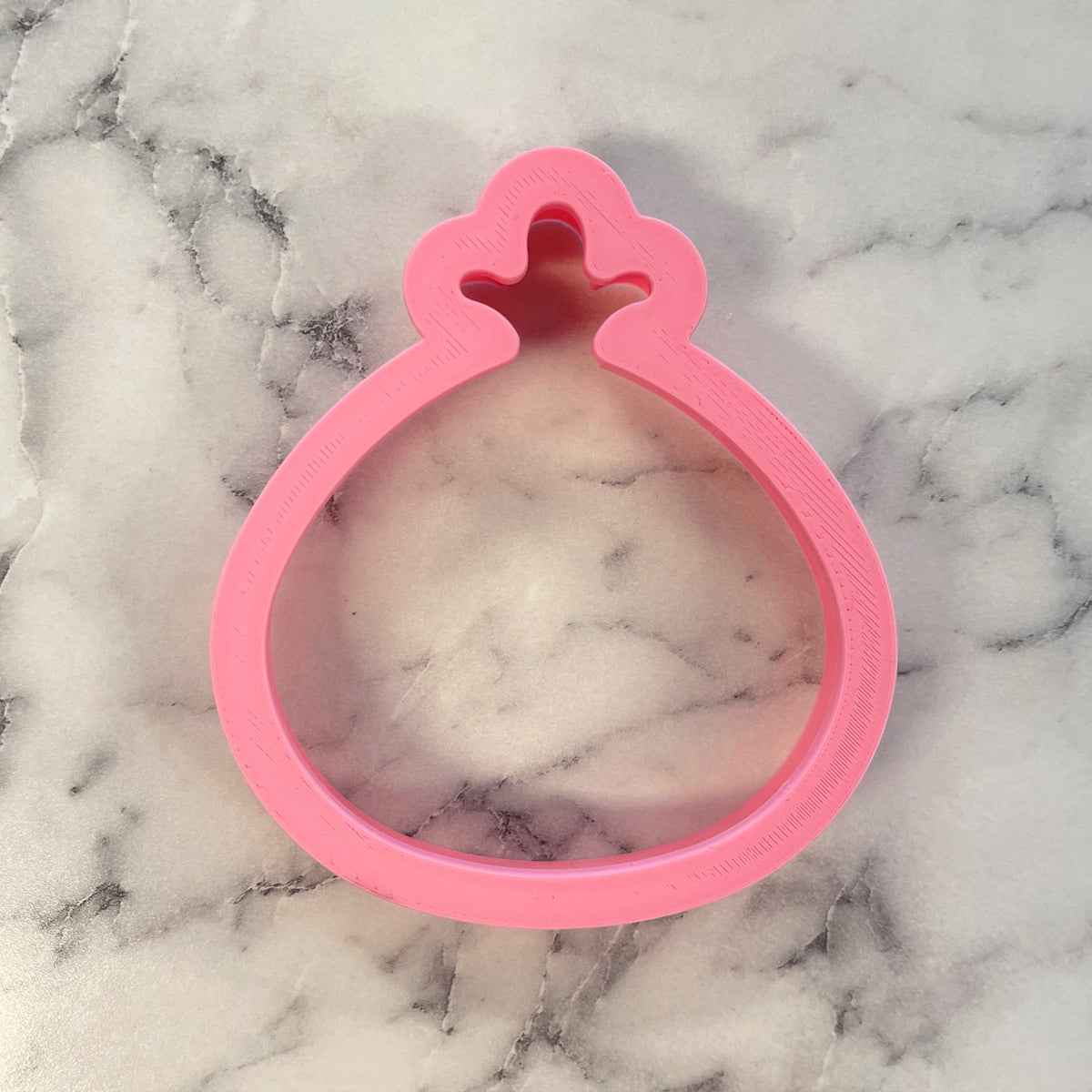 Pink plastic thanksgiving turkey cookie cutter shaped like a bag with a decorative top for holiday baking