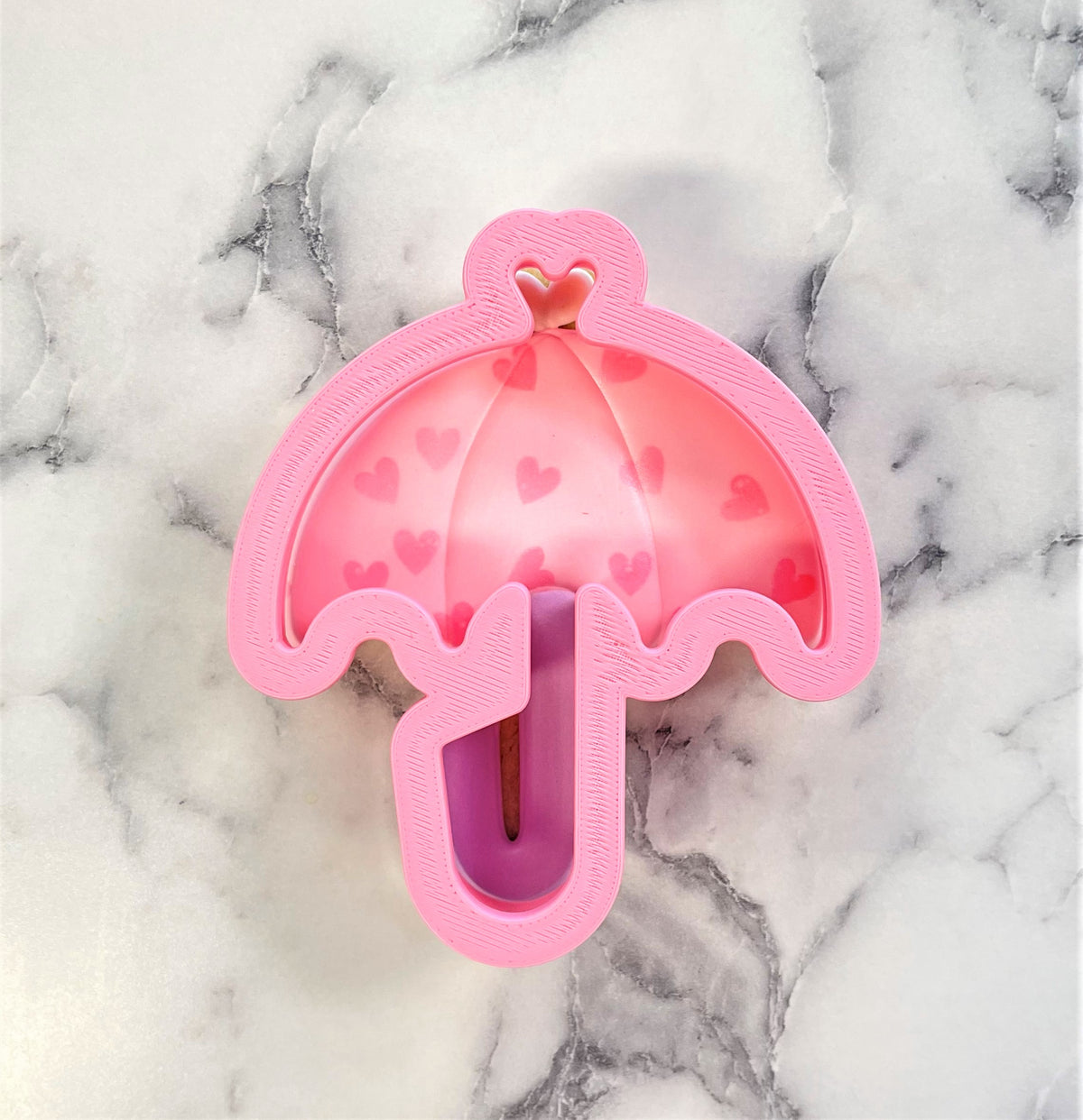 Pink umbrella cookie cutter night light with translucent heart patterned canopy and solid pink frame