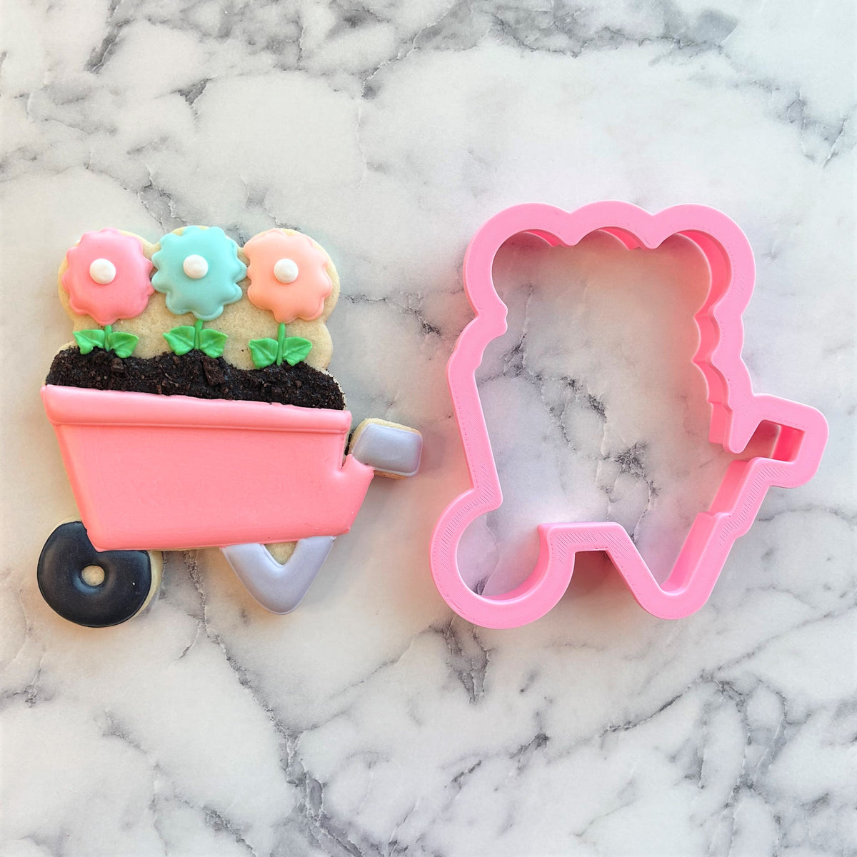 Pink plastic wheelbarrow cookie cutter with floral design for baking and decorating cookies