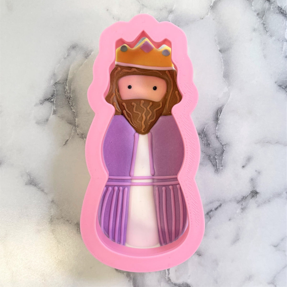 Pink silicone wiseman cookie cutter shaped like a king with brown beard purple white robe and gold crown