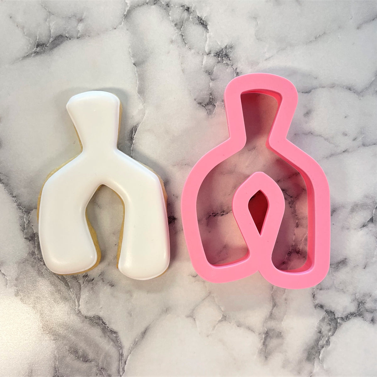 Pink and white silicone wishbone cookie cutters shaped like bottle outlines for baking and decorating