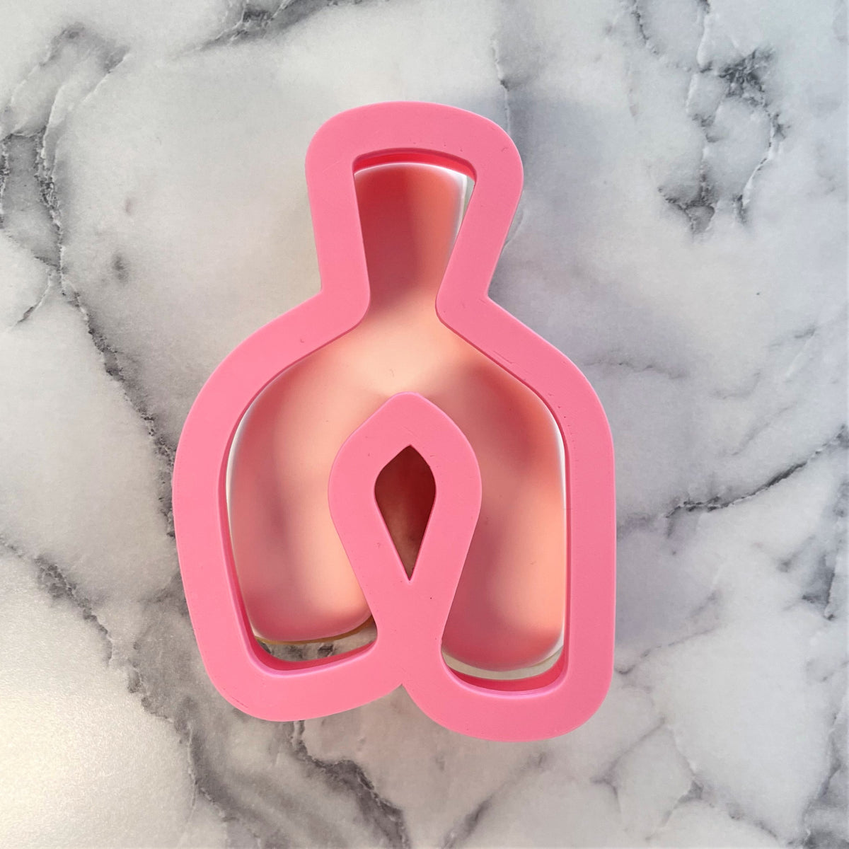 Pink silicone wishbone cookie cutter shaped like a bottle for baking and shaping cookies