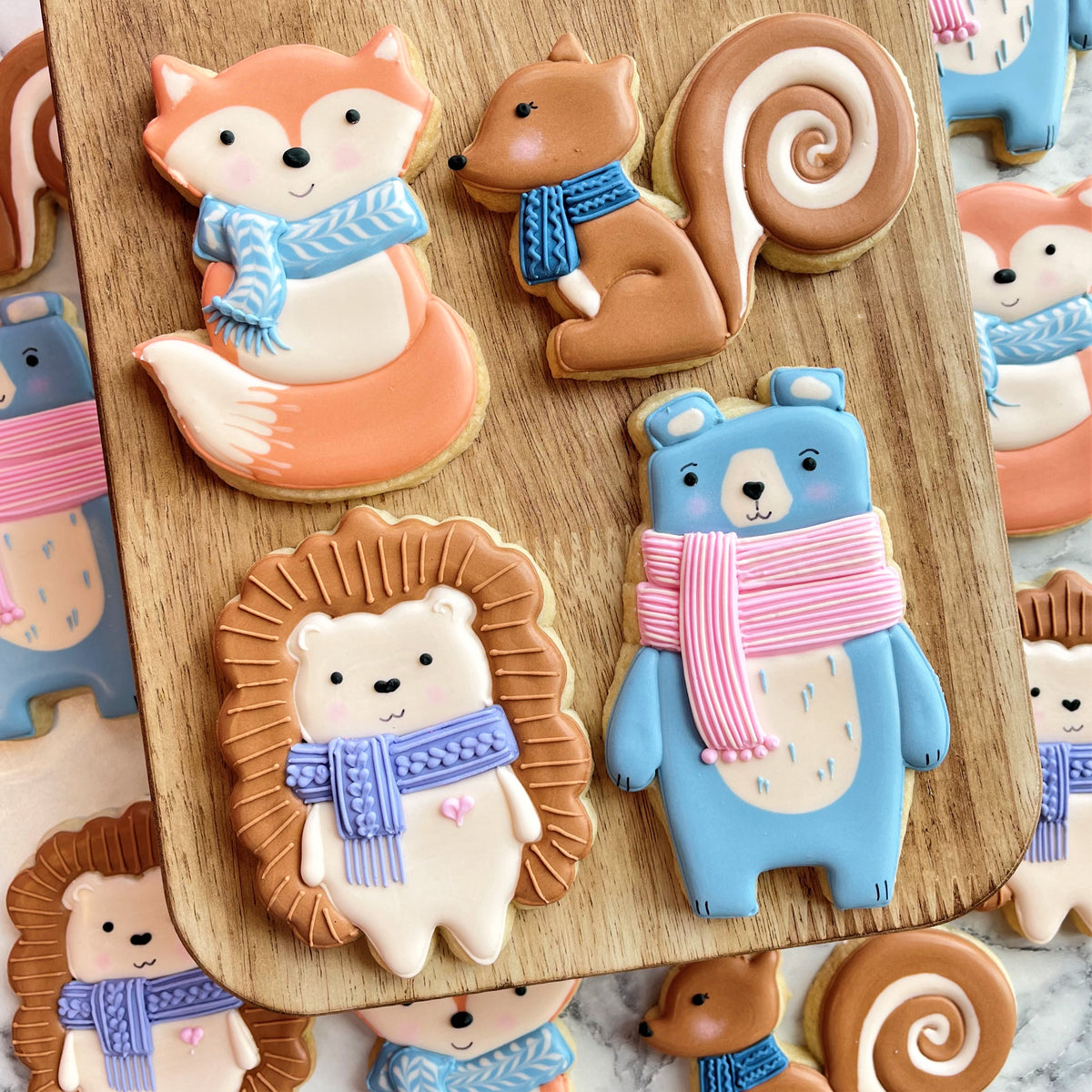 Cute pastel-colored woodland fox sugar cookies decorated with icing scarves and detailed facial features
