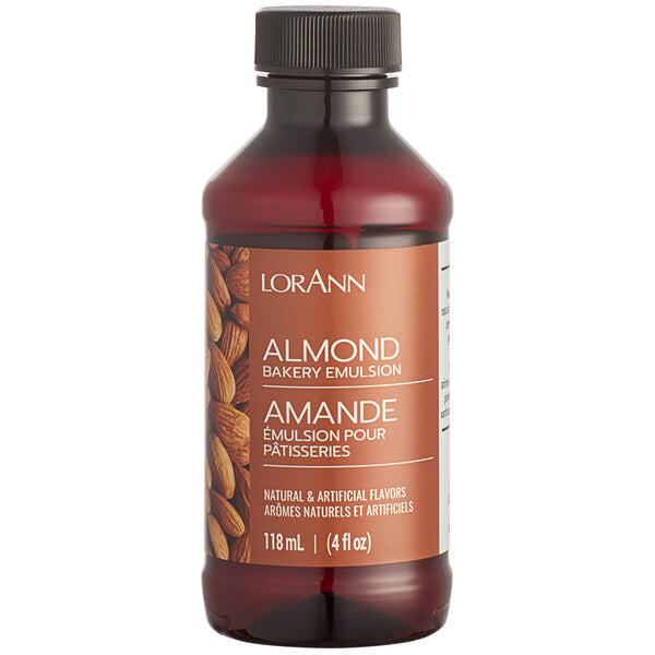 A dark amber glass bottle with a black cap labeled lorann almond bakery emulsion in white on an orange almond label