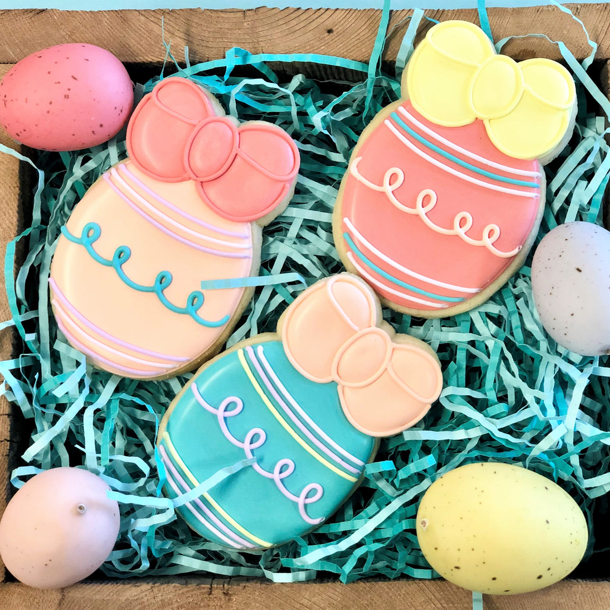 Easter cookie cutter set featuring pastel-colored easter egg-shaped sugar cookies with decorative bows and icing details