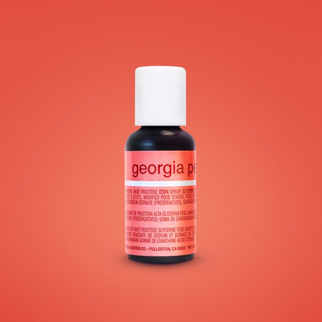 A small bottle of georgia pacific orange-labeled food coloring with white cap containing dark georgia peach liquid