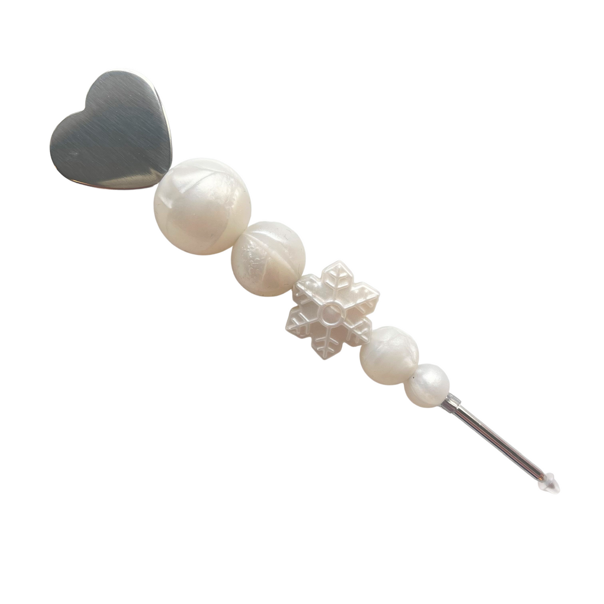 A delicate silver heart-shaped hair clip with white pearls and a snowflake charm from let it snow cookie scribe