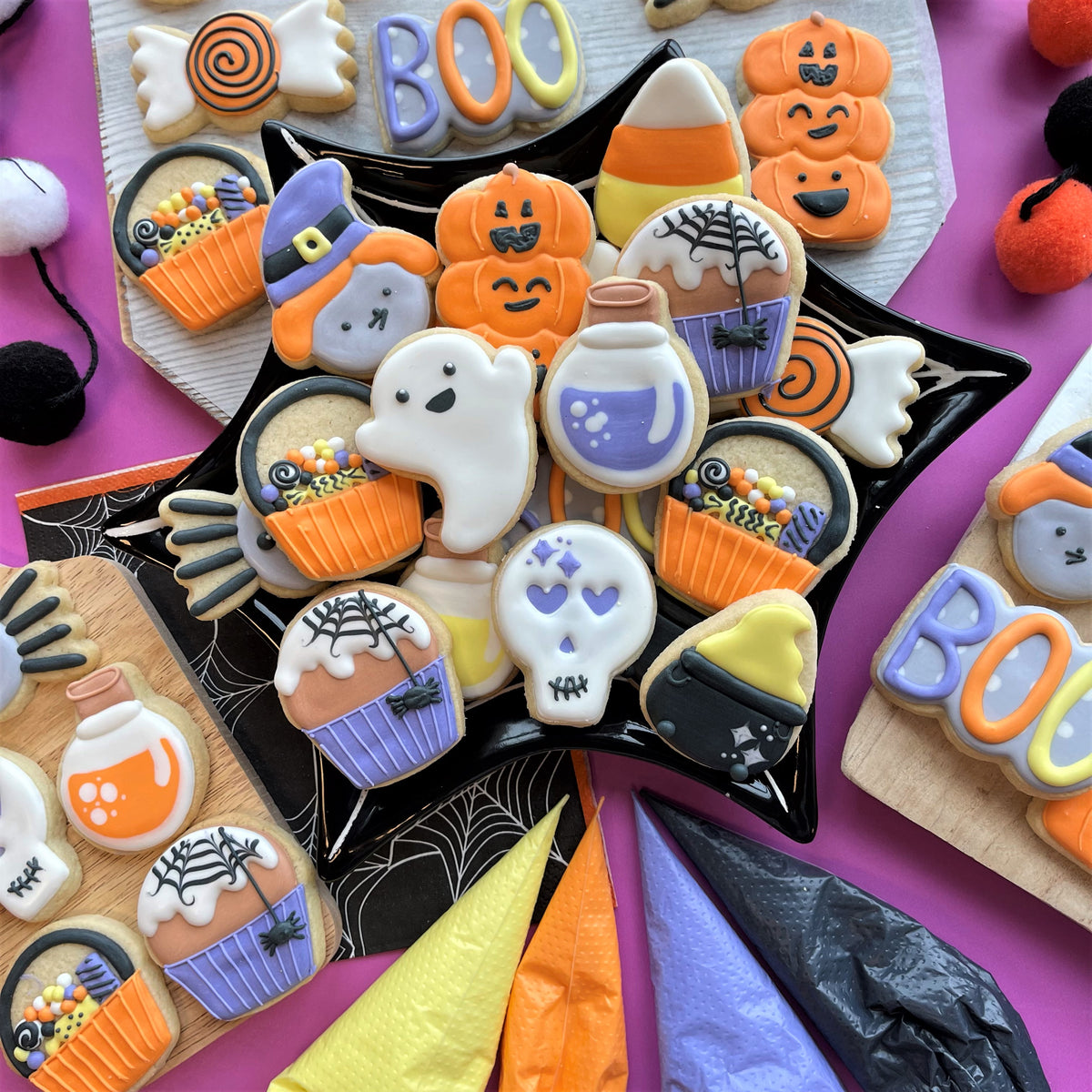 A black star-shaped plate with halloween-themed sugar cookies made using mini cupcake cookie flip cutter