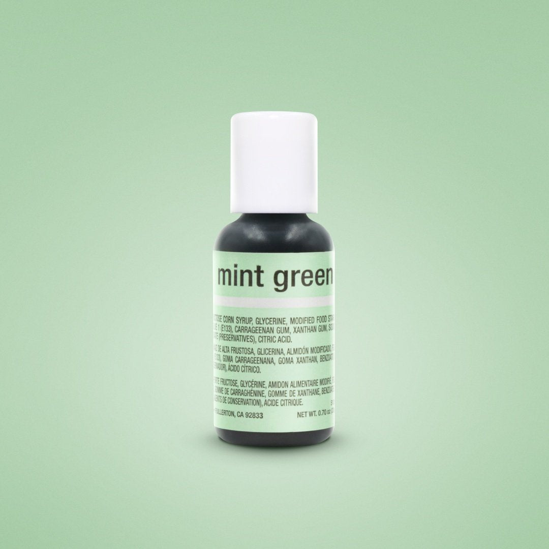 A sleek dark glass bottle with a white cap and mint green label containing mint green food coloring chefmaster liqua-gel