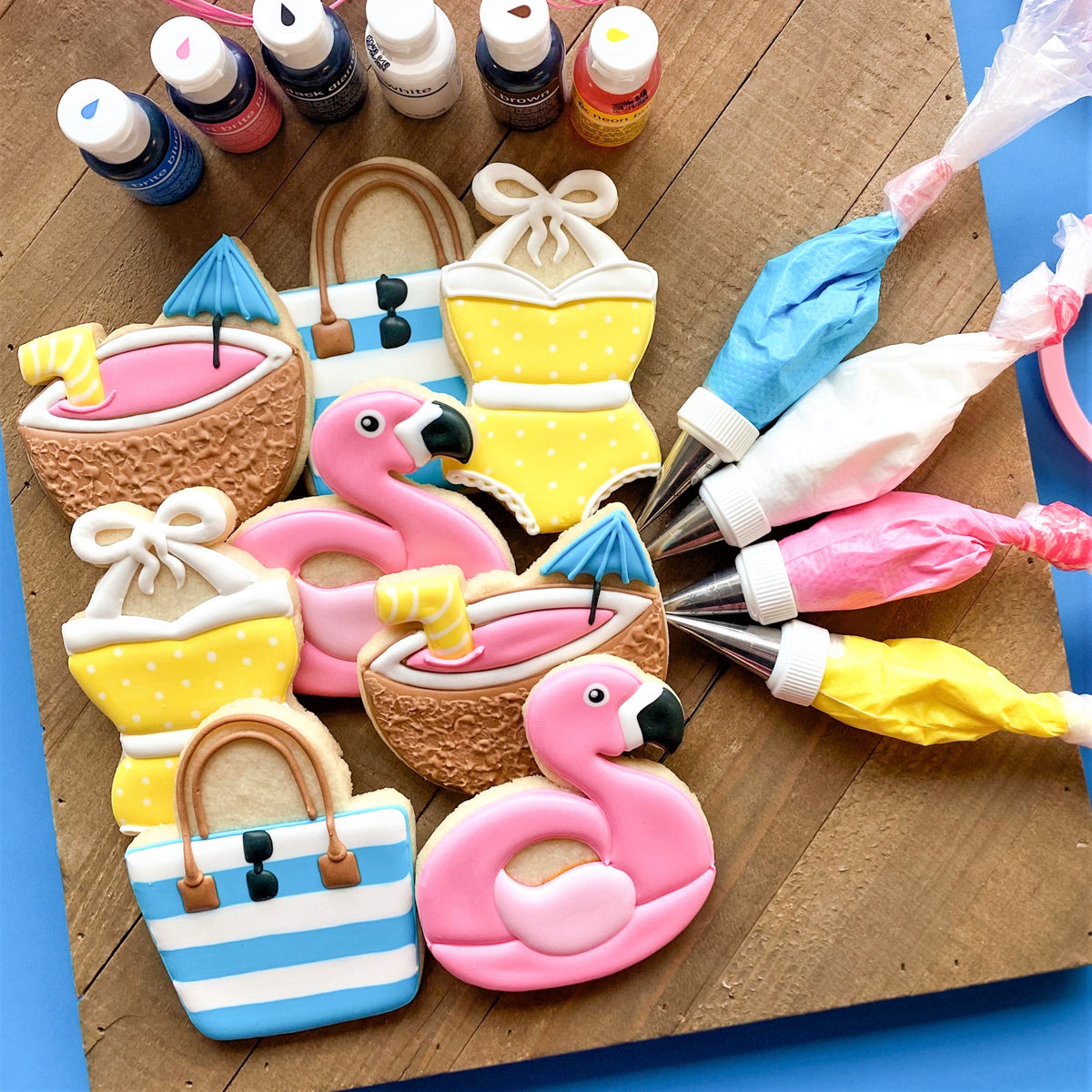 Pink flamingo-shaped sugar cookies with black beaks and white icing details from pool party cookie cutter set