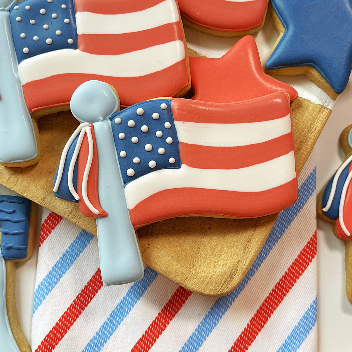 A red white and blue american flag shaped cookie decorated with icing from the sweet land of liberty cookie kit