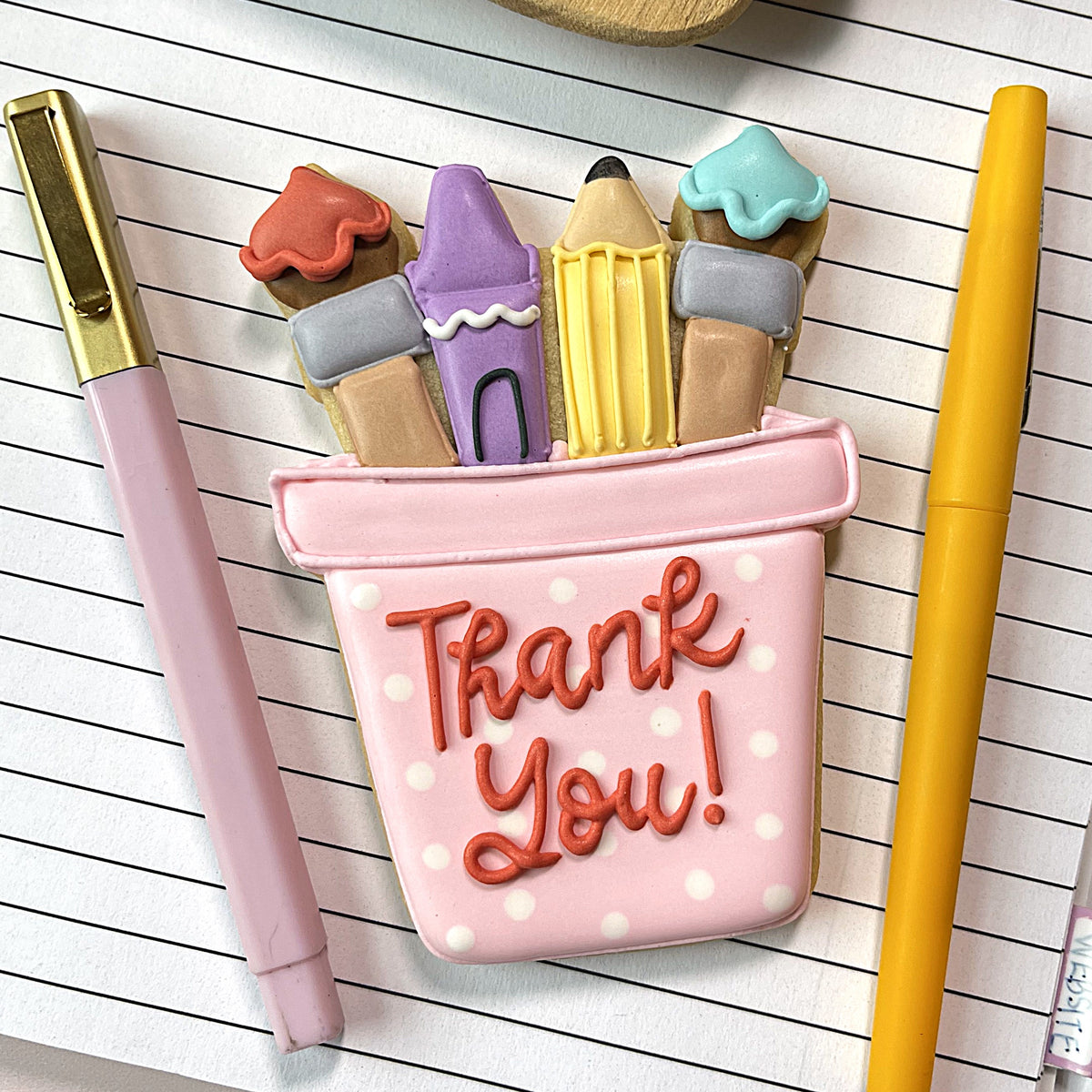 School cookie cutter bundle featuring a pink polka-dotted pencil case cookie with colorful crayon cookies and thank you icing