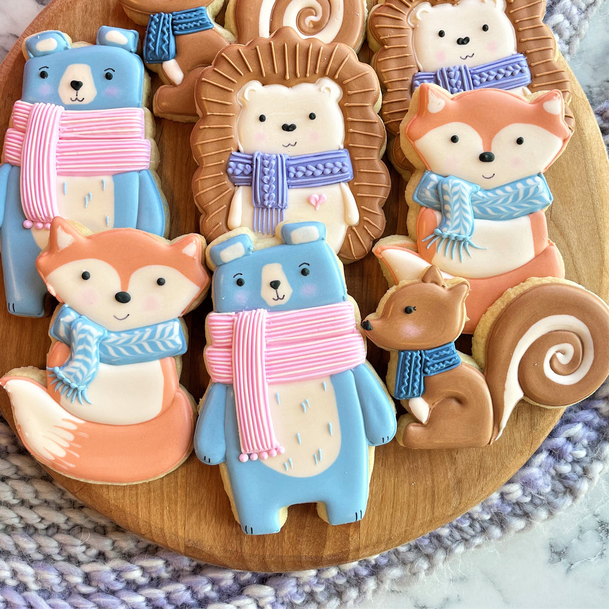Cute woodland animals cookie cutter set featuring blue bear-shaped sugar cookies with pink striped scarves and white icing details