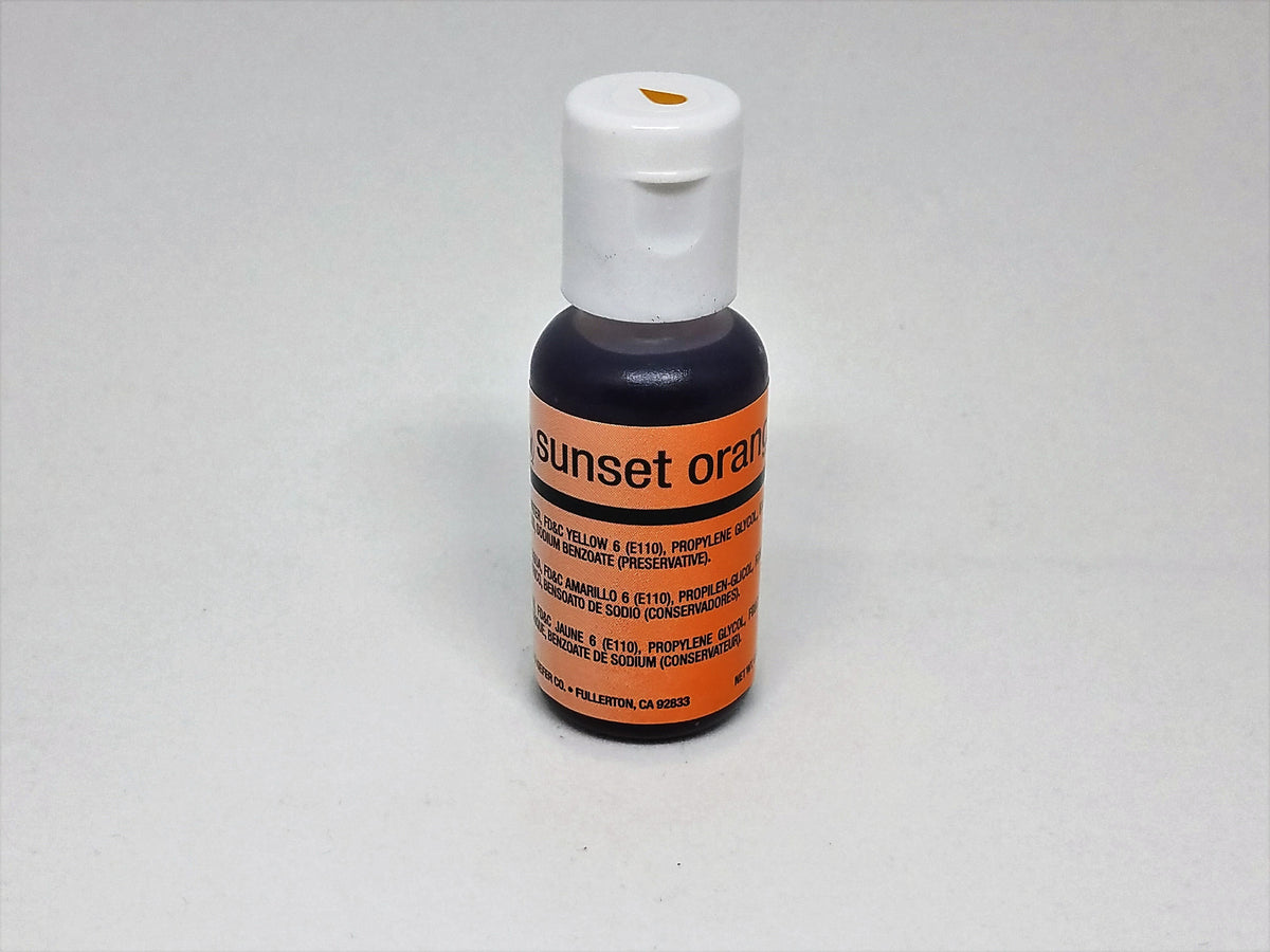 A small bottle of sunset orange chefmaster airbrush color food coloring with a white cap and orange label